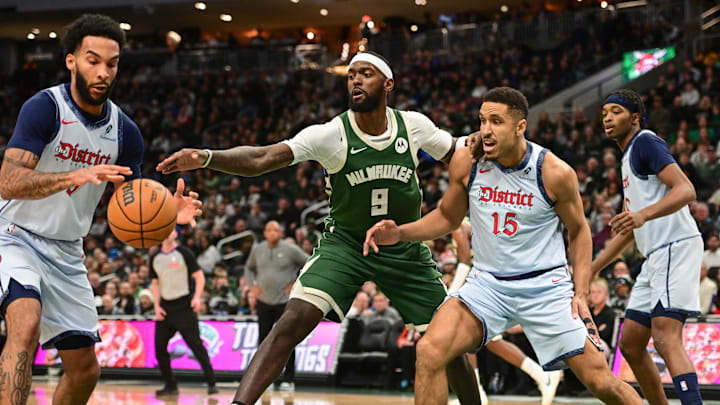 Dec 21, 2024; Milwaukee, Wisconsin, USA;  Milwaukee Bucks forward Bobby Portis (9) reaches for the ball against Washington Wizards forward Justin Champagnie (9) and  guard Malcolm Brogdon (15) in the second quarter at Fiserv Forum. Mandatory Credit: Benny Sieu-Imagn Images