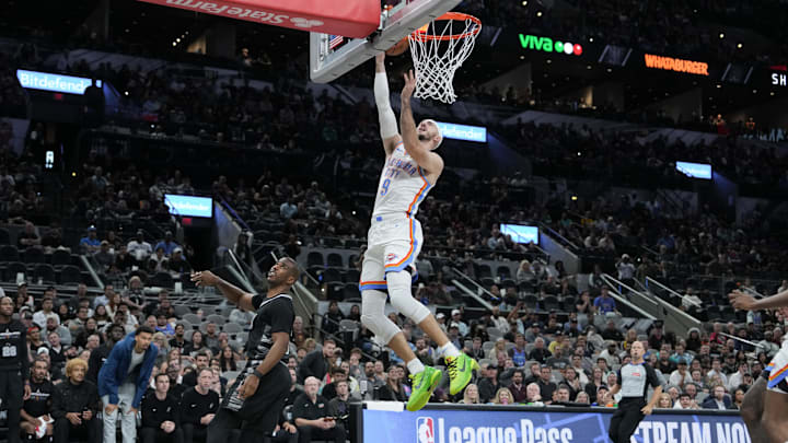 Nov 19, 2024; San Antonio, Texas, USA;  Oklahoma City Thunder guard Alex Caruso (9) lays the ball in over San Antonio Spurs guard Chris Paul (3) in the second half at Frost Bank Center. Mandatory Credit: Daniel Dunn-Imagn Images