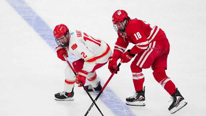 Apr 11, 2026; Las Vegas, Nevada, United States; Denver Pioneers defenseman Tory Pitner (2) and Wisconsin Badgers forward Adam Pietila (18) battle for control of the puck during the first period in the championship game of the NCAA men's ice hockey Frozen Four at T-Mobile Arena. Mandatory Credit: Stephen R. Sylvanie-Imagn Images