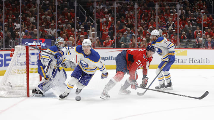 Mar 30, 2025; Washington, District of Columbia, USA; Buffalo Sabres defenseman Bowen Byram (4) battles for the puck with Washington Capitals center Aliaksei Protas (21) during the third period at Capital One Arena. Mandatory Credit: Amber Searls-Imagn Images