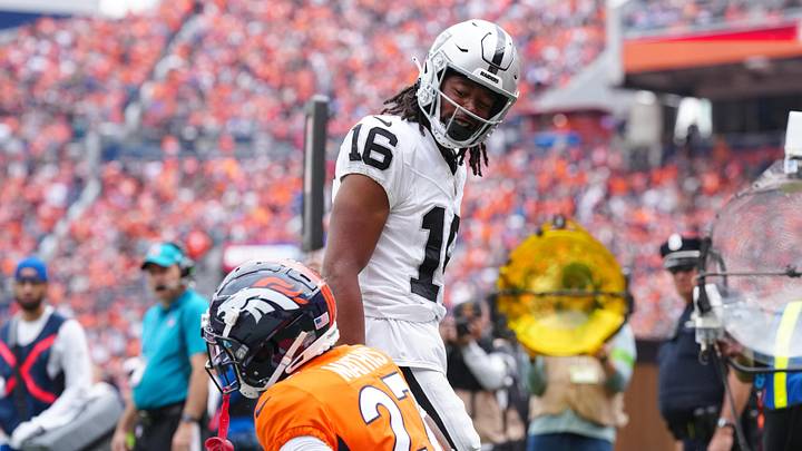 Sep 10, 2023; Denver, Colorado, USA; Las Vegas Raiders wide receiver Jakobi Meyers (16) reacts towards Denver Broncos cornerback Damarri Mathis (27) following his touchdown reception in the first quarter at Empower Field at Mile High. Mandatory Credit: Ron Chenoy-Imagn Images