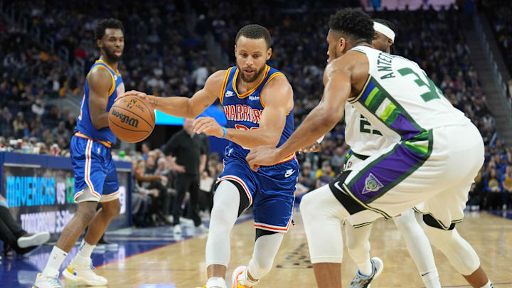 Mar 12, 2022; San Francisco, California, USA; Golden State Warriors guard Stephen Curry (30) dribbles against Milwaukee Bucks forward Giannis Antetokounmpo (34) during the third quarter at Chase Center. Mandatory Credit: Darren Yamashita-Imagn Images