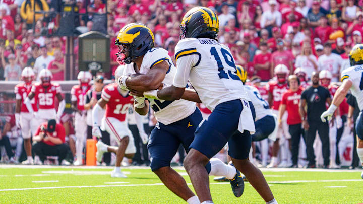Sep 20, 2025; Lincoln, Nebraska, USA; Michigan Wolverines quarterback Bryce Underwood (19) hands the ball off to running back Justice Haynes (22) for a touchdown against the Nebraska Cornhuskers during the second quarter at Memorial Stadium. Mandatory Credit: Dylan Widger-Imagn Images
