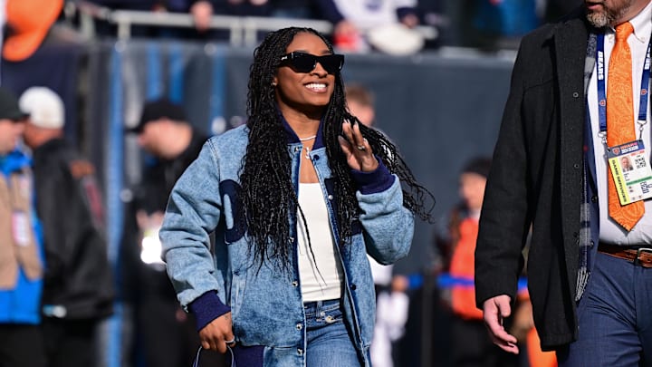 Simone Biles walks on the field before a Chicago Bears game.