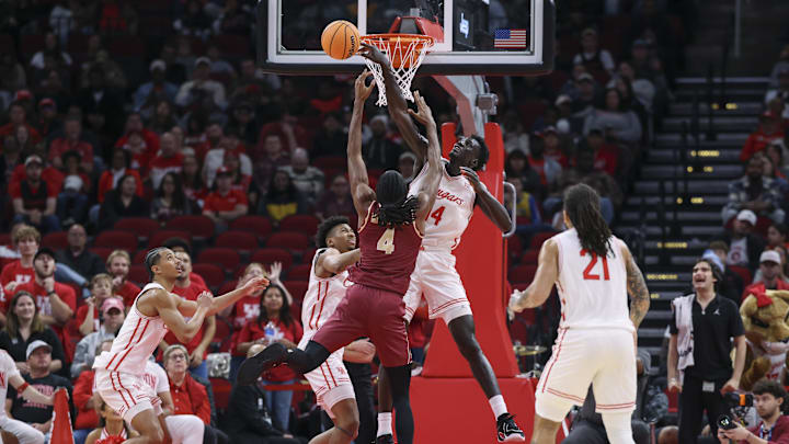 Dec 5, 2025; Houston, Texas, USA; Houston Cougars forward Kalifa Sakho (14) attempts to block a shot by Florida State Seminoles forward Shah Muhammad (4) during the first half at Toyota Center. Mandatory Credit: Troy Taormina-Imagn Images
