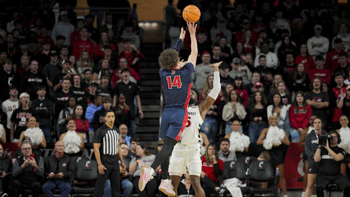 Nov 10, 2023; Cincinnati, Ohio, USA; Detroit Mercy Titans guard Jayden Stone (14) shoots against Cincinnati Bearcats forward John Newman III (15) in the first half at Fifth Third Arena. Mandatory Credit: Aaron Doster-Imagn Images Nov 10, 2023; Cincinnati, Ohio, USA; Detroit Mercy Titans guard Jayden Stone (14) shoots against Cincinnati Bearcats forward John Newman III (15) in the first half at Fifth Third Arena. Mandatory Credit: Aaron Doster-Imagn Images