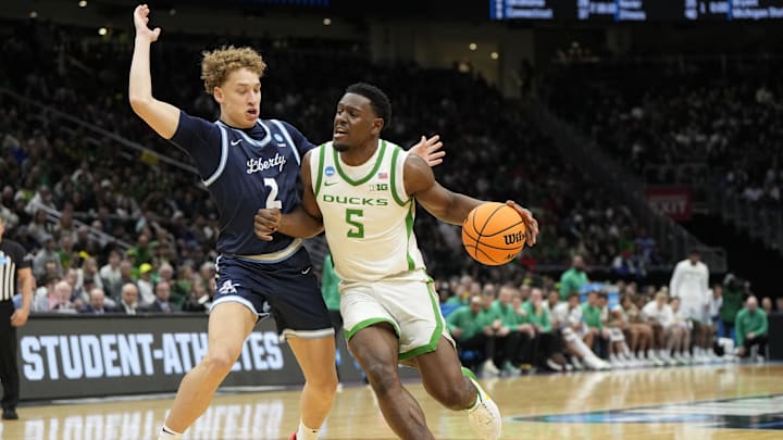 Mar 21, 2025; Seattle, WA, USA; Oregon Ducks guard TJ Bamba (5) dribbles the ball against Liberty Flames guard Taelon Peter (2) during the first half in the first round of the NCAA Tournament  at Climate Pledge Arena. Mandatory Credit: Stephen Brashear-Imagn Images