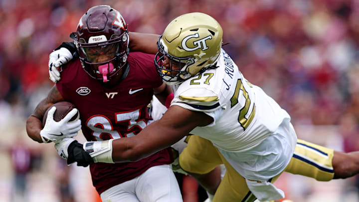 Oct 26, 2024; Blacksburg, Virginia, USA; Georgia Tech Yellow Jackets defensive lineman Joshua Robinson (27) tackles Virginia Tech Hokies wide receiver Jaylin Lane (83) during the second quarter at Lane Stadium. Mandatory Credit: Peter Casey-Imagn Images