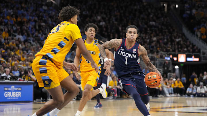 Feb 1, 2025; Milwaukee, Wisconsin, USA;  Connecticut Huskies guard Solo Ball (1) drives for the basket against Marquette Golden Eagles forward Royce Parham (13) during the first half at Fiserv Forum. Mandatory Credit: Jeff Hanisch-Imagn Images