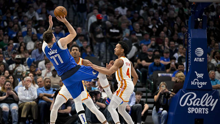 Apr 4, 2024; Dallas, Texas, USA; Dallas Mavericks guard Luka Doncic (77) is fouled as he shoots over Atlanta Hawks guard Kobe Bufkin (4) during the first half at the American Airlines Center. Mandatory Credit: Jerome Miron-USA TODAY Sports