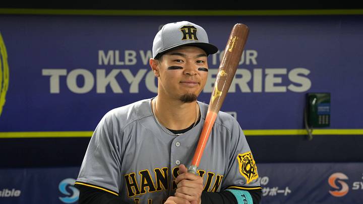 Mar 15, 2025; Bunkyo, Tokyo, Japan; Hanshin Tigers right fielder Teruaki Sato (8) poses for a photo after defeating the Chicago Cubs at Tokyo Dome. Mandatory Credit: Darren Yamashita-Imagn Images