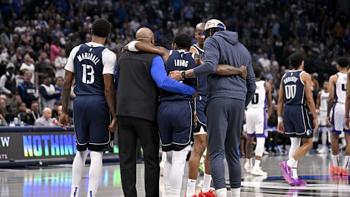Mar 3, 2025; Dallas, Texas, USA; Dallas Mavericks guard Kyrie Irving (11) is helped off the court by forward Naji Marshall (13) and forward Anthony Davis (3) during the second quarter against the Sacramento Kings at the American Airlines Center. Mandatory Credit: Jerome Miron-Imagn Images