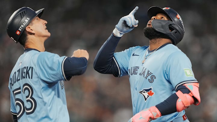 Oct 16, 2025; Seattle, Washington, USA; Toronto Blue Jays first baseman Vladimir Guerrero Jr. (27) celebrates with first base coach Mark Budzinski (53) after hitting a single against the Seattle Mariners in the third inning during game four of the ALCS round for the 2025 MLB playoffs at T-Mobile Park. 