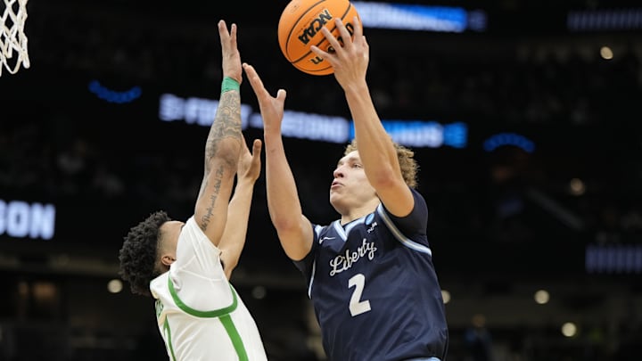 Mar 21, 2025; Seattle, WA, USA; Liberty Flames guard Taelon Peter (2) shoots the ball over Oregon Ducks guard Ra'Heim Moss (0) during the second half in the first round of the NCAA Tournament  at Climate Pledge Arena.