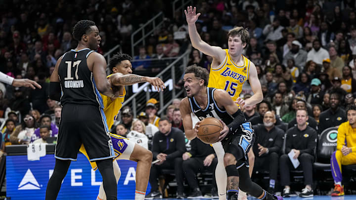 Jan 30, 2024; Atlanta, Georgia, USA; Atlanta Hawks guard Trae Young (11) dribbles against Los Angeles Lakers guard Austin Reaves (15) during the second half at State Farm Arena. Mandatory Credit: Dale Zanine-Imagn Images