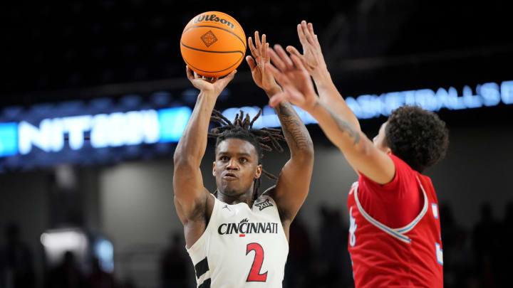 Cincinnati Bearcats guard Jizzle James (2) rises for a shot as Bradley Braves guard Trey Pettigrew (3) defends in the second half of a college basketball game during a second-round game of the National Invitation Tournament,, Saturday, March 23, 2024, at Fifth Third Arena in Cincinnati.