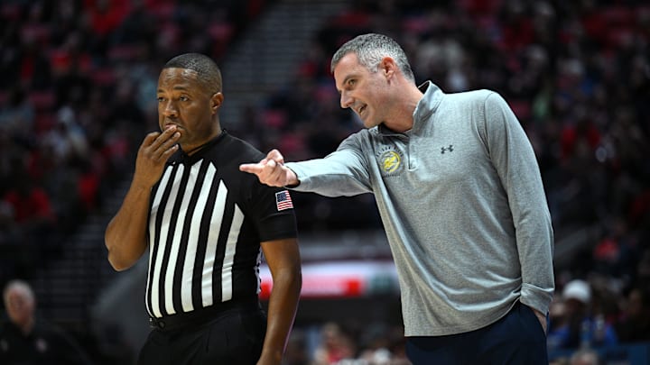 Dec 20, 2022; San Diego, California, USA; UC San Diego Tritons head coach Eric Olen (right) talks to referee Keith Kimble during the first half against the San Diego State Aztecs at Viejas Arena. Mandatory Credit: Orlando Ramirez-Imagn Images