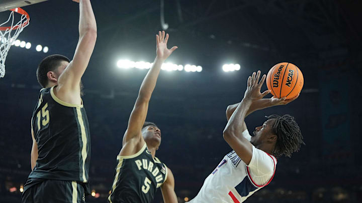 Apr 8, 2024; Glendale, AZ, USA; Connecticut Huskies guard Tristen Newton (2) shoots the ball against Purdue Boilermakers center Zach Edey (15) and guard Myles Colvin (5) during the first half of the national championship game of the Final Four of the 2024 NCAA Tournament at State Farm Stadium. Mandatory Credit: Bob Donnan-USA TODAY Sports