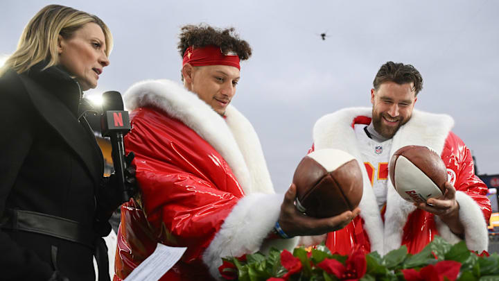 Dec 25, 2024; Pittsburgh, Pennsylvania, USA; Kansas City Chiefs quarterback Patrick Mahomes (15) and tight end Travis Kelce (87) look at  football cakes while being interviewed by Netflix reporter Stacey Dales following their win against the Pittsburgh Steelers at Acrisure Stadium. Mandatory Credit: Barry Reeger-Imagn Images