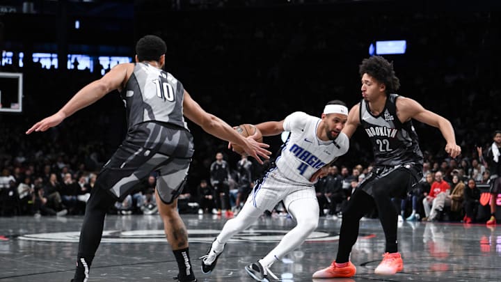 Dec 1, 2024; Brooklyn, New York, USA; Orlando Magic guard Jalen Suggs (4) drives to the basket while being defended by Brooklyn Nets guard Ben Simmons (10) and Brooklyn Nets forward Jalen Wilson (22) during the first half at Barclays Center. Mandatory Credit: John Jones-Imagn Images Dec 1, 2024; Brooklyn, New York, USA; Orlando Magic guard Jalen Suggs (4) drives to the basket while being defended by Brooklyn Nets guard Ben Simmons (10) and Brooklyn Nets forward Jalen Wilson (22) during the first half at Barclays Center. Mandatory Credit: John Jones-Imagn Images