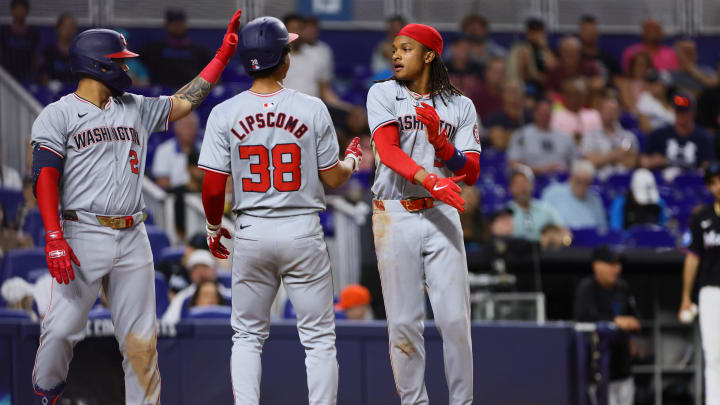 Apr 26, 2024; Miami, Florida, USA; Washington Nationals shortstop CJ Abrams (5) celebrates with third baseman Trey Lipscomb (38) and second baseman Luis Garcia Jr. (2) after scoring against the Miami Marlins during the eighth inning at loanDepot Park.