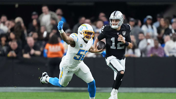 Raiders quarterback Aidan O'Connell (12) carries the ball against Chargers linebacker Khalil Mack (52) Raiders quarterback Aidan O'Connell (12) carries the ball against Chargers linebacker Khalil Mack (52)