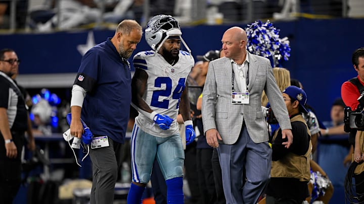 Sep 28, 2025; Arlington, Texas, USA; Dallas Cowboys running back Miles Sanders (24) walks off the field with team staff during the game between the Dallas Cowboys and the Green Bay Packers at AT&T Stadium. Mandatory Credit: Jerome Miron-Imagn Images