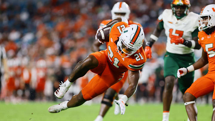 Sep 7, 2024; Miami Gardens, Florida, USA; Miami Hurricanes running back Jordan Lyle (21) runs with the football against the Florida A&M Rattlers during the third quarter at Hard Rock Stadium. Mandatory Credit: Sam Navarro-Imagn Images