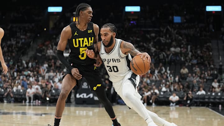 Oct 12, 2024; San Antonio, Texas, USA; San Antonio Spurs forward Julian Champagnie (30) dribbles against Utah Jazz forward Cody Williams (5) in the second half at Frost Bank Center.