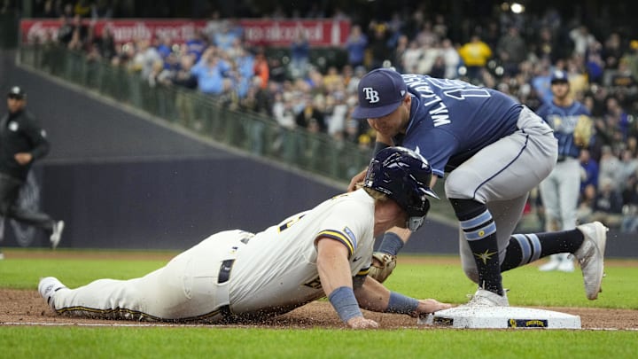 Apr 1, 2026; Milwaukee, Wisconsin, USA; Milwaukee Brewers first baseman Jake Bauers (9) slides into third base safely ahead of the tag by Tampa Bay Rays third baseman Ben Williamson (15) in the eighth inning at American Family Field. Mandatory Credit: Michael McLoone-Imagn Images