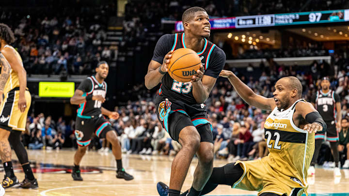 Dec 20, 2025; Memphis, Tennessee, USA; Memphis Grizzlies forward Cedric Coward (23) drives into defender Washington Wizards Forward Khris Middleton (22) in the fourth quarter at FedExForum. Mandatory Credit: Matthew Smith-Imagn Images