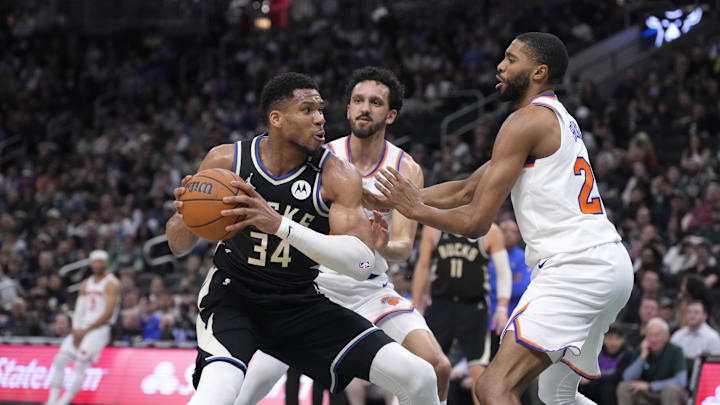 Mar 28, 2025; Milwaukee, Wisconsin, USA; Milwaukee Bucks forward Giannis Antetokounmpo (34) puts up a shot against New York Knicks guard Landry Shamet (44) and New York Knicks forward Mikal Bridges (25) in the first half  at Fiserv Forum. Mandatory Credit: Michael McLoone-Imagn Images