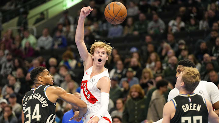 Nov 12, 2024; Milwaukee, Wisconsin, USA;  Toronto Raptors guard Gradey Dick (1) passes the ball away from Milwaukee Bucks forward Giannis Antetokounmpo (34) during the second quarter at Fiserv Forum. Mandatory Credit: Jeff Hanisch-Imagn Images