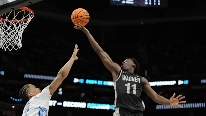 March 21, 2024, Charlotte, NC, USA; Wagner Seahawks guard Melvin Council Jr. (11) shoots against North Carolina Tar Heels guard Seth Trimble (7) in the first round of the 2024 NCAA Tournament at the Spectrum Center. Mandatory Credit: Bob Donnan-Imagn Images