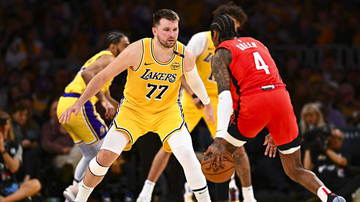 Apr 11, 2025; Los Angeles, California, USA; Los Angeles Lakers guard Luka Doncic (77) defends against Houston Rockets guard Jalen Green (4) during the first half at Crypto.com Arena. Mandatory Credit: Jonathan Hui-Imagn Images
