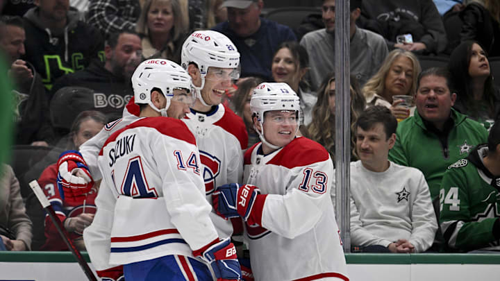 Jan 16, 2025; Dallas, Texas, USA; Montreal Canadiens center Nick Suzuki (14) and left wing Juraj Slafkovsky (20) and right wing Cole Caufield (13) celebrates a goal scored Slafkovsky against the Dallas Stars during the first period at the American Airlines Center. Mandatory Credit: Jerome Miron-Imagn Images