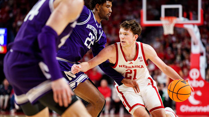 Feb 14, 2026; Lincoln, Nebraska, USA; Nebraska Cornhuskers forward Pryce Sandfort (21) drives against Northwestern Wildcats forward Arrinten Page (22) and guard Angelo Ciaravino (44) during the first half at Pinnacle Bank Arena. 