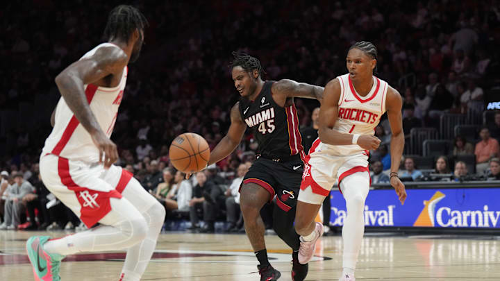 Mar 21, 2025; Miami, Florida, USA;  Houston Rockets forward Amen Thompson (1) forces a turnover as Miami Heat guard Davion Mitchell (45) looses possession to forward Tari Eason, left, in the second half at Kaseya Center. Mandatory Credit: Jim Rassol-Imagn Images