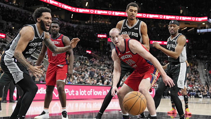 Feb 2, 2024; San Antonio, Texas, USA; San Antonio Spurs forward Julian Champagnie (30) reacts as he battles for a loose ball with New Orleans Pelicans center Cody Zeller (40) during the first half at Frost Bank Center. Mandatory Credit: Scott Wachter-Imagn Images