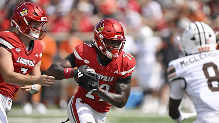 Sep 20, 2025; Louisville, Kentucky, USA;  Louisville Cardinals running back Keyjuan Brown (22) runs the ball against Bowling Green Falcons cornerback Jalen McClendon (8) during the first half at L&N Federal Credit Union Stadium. Mandatory Credit: Jamie Rhodes-Imagn Images