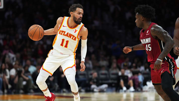 Feb 26, 2025; Miami, Florida, USA;  Atlanta Hawks guard Trae Young (11) brings the ball up the court as Miami Heat guard Davion Mitchell (45) defends in the second half at Kaseya Center. Mandatory Credit: Jim Rassol-Imagn Images