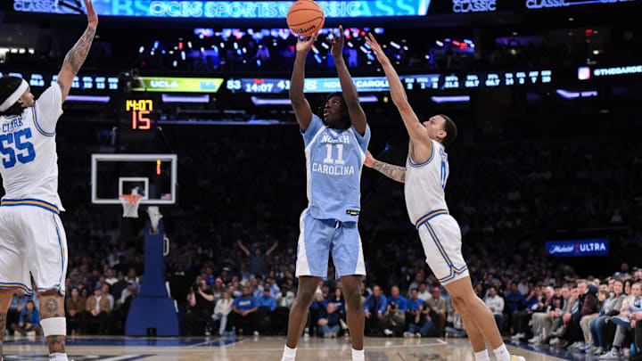 Dec 21, 2024; New York, NY, USA; North Carolina Tar Heels guard Ian Jackson (11) shoots the ball while being defended by UCLA Bruins guard Kobe Johnson (0) during the second half at Madison Square Garden. Mandatory Credit: John Jones-Imagn Images