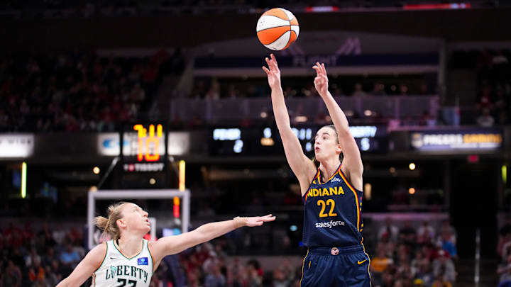 Indiana Fever guard Caitlin Clark (22) shoots a three-pointer while being guarded by New York Liberty guard Courtney Vandersloot (22) on Thursday, May 16, 2024, during the Indiana Fever home opener game against the New York Liberty at Gainbridge Fieldhouse in Indianapolis.