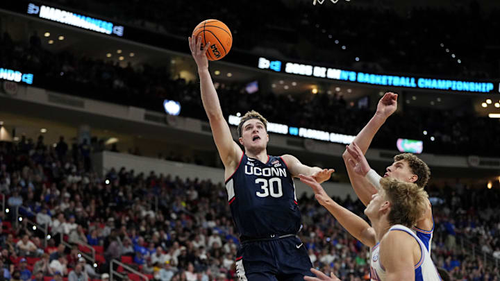 Mar 23, 2025; Raleigh, NC, USA; Connecticut Huskies forward Liam McNeeley (30) drives to the basket as Florida Gators guard Alijah Martin (15) defends during the second half in the second round of the NCAA Tournament at Lenovo Center. Mandatory Credit: Bob Donnan-Imagn Images