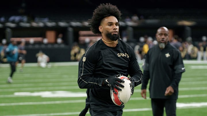 Aug 17, 2025; New Orleans, Louisiana, USA; New Orleans Saints wide receiver Chris Olave (12) warms up with a rugby ball against the Jacksonville Jaguars at Caesars Superdome. Mandatory Credit: Matthew Hinton-Imagn Images