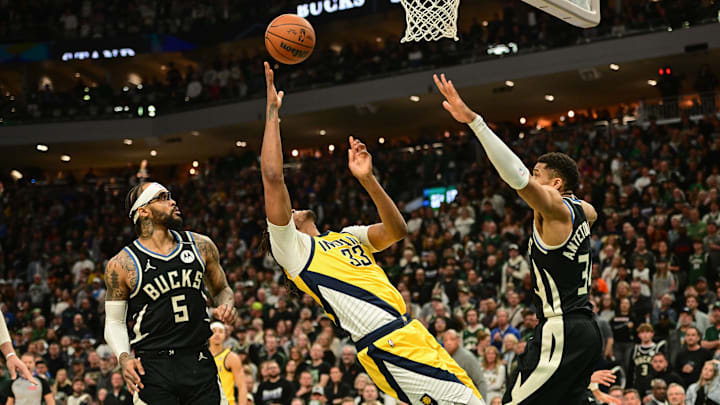Apr 27, 2025; Milwaukee, Wisconsin, USA; Indiana Pacers center Myles Turner (33) reaches for the ball against Milwaukee Bucks guard Gary Trent Jr. (5) and forward Giannis Antetokounmpo (34) in the first quarter during game four of first round for the 2024 NBA Playoffs at Fiserv Forum. Mandatory Credit: Benny Sieu-Imagn Images