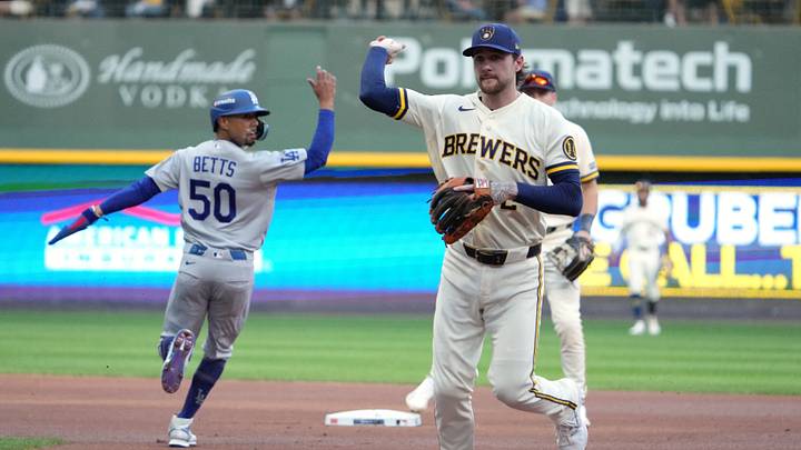 Oct 12, 2026; Milwaukee, Wisconsin, USA; Milwaukee Brewers infielder Brice Turang (2) throws the ball to first base for an out after fielding a ground ball hit by Los Angeles Dodgers infielder Freddie Freeman (not pictured) as infielder Mookie Betts (50) runs toward second base during the first inning in game two of the NLCS for the 2026 MLB Playoffs at American Family Field. Mandatory Credit: Michael McLoone-Imagn Images Oct 12, 2026; Milwaukee, Wisconsin, USA; Milwaukee Brewers infielder Brice Turang (2) throws the ball to first base for an out after fielding a ground ball hit by Los Angeles Dodgers infielder Freddie Freeman (not pictured) as infielder Mookie Betts (50) runs toward second base during the first inning in game two of the NLCS for the 2026 MLB Playoffs at American Family Field. Mandatory Credit: Michael McLoone-Imagn Images