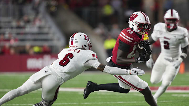 Aug 28, 2025; Madison, Wisconsin, USA;  Wisconsin Badgers wide receiver Eugene Hilton Jr. (13) rushes with the football against Miami (OH) RedHawks defensive back Adrian Walker Jr. (6) during the third quarter at Camp Randall Stadium. Mandatory Credit: Jeff Hanisch-Imagn Images
