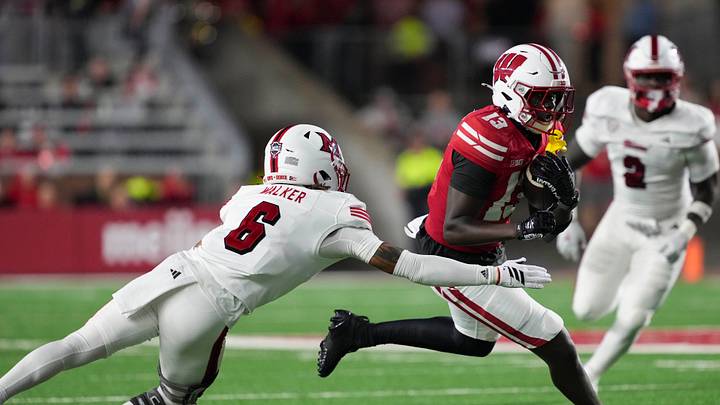 Aug 28, 2025; Madison, Wisconsin, USA;  Wisconsin Badgers wide receiver Eugene Hilton Jr. (13) rushes with the football against Miami (OH) RedHawks defensive back Adrian Walker Jr. (6) during the third quarter at Camp Randall Stadium. Mandatory Credit: Jeff Hanisch-Imagn Images