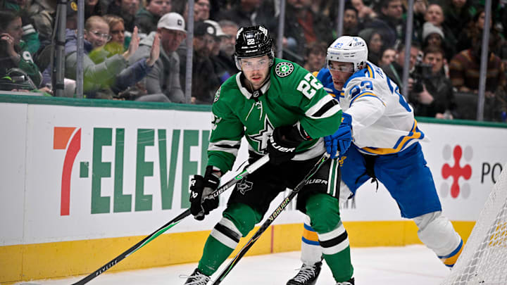 Jan 23, 2026; Dallas, Texas, USA; Dallas Stars center Mavrik Bourque (22) keeps the puck away from St. Louis Blues defenseman Logan Mailloux (23) during the second period at the American Airlines Center. Mandatory Credit: Jerome Miron-Imagn Images